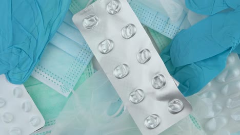 discarded empty blister pill packs, surgical gloves and masks piled up - overhead close up slide up shot