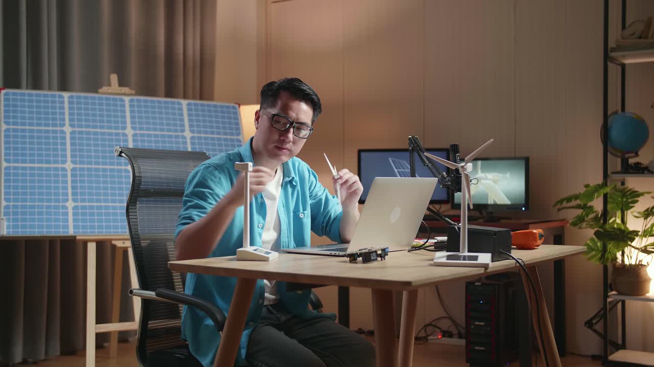 Uomo che lavora su modelli di energia rinnovabile a casa
