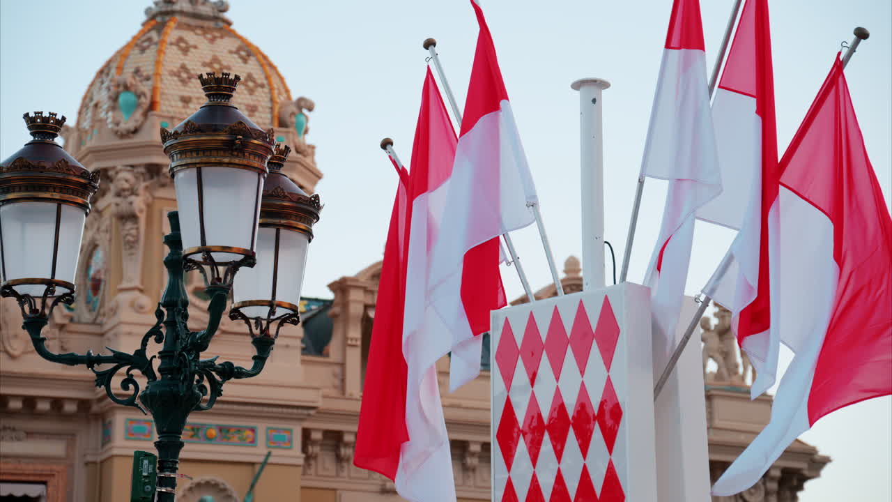 Monte Carlo, Monaco - October 24, 2024: The coat of arms of Monaco and multiple flags waving in front of the Monte Carlo Casino