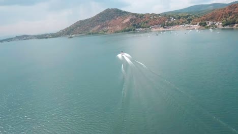 vista aérea mientras volaba con un dron fpv siguiendo una lancha deportiva rápida en el lago zemplinska sirava en el este de eslovaquia