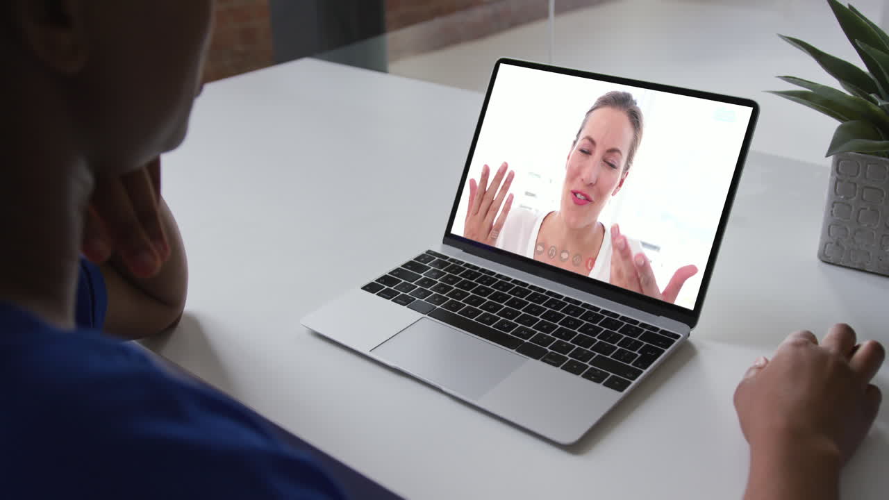 Mid section of african american woman having a video call on laptop with female colleague at office