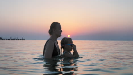 mother tossing child in air during sea swim