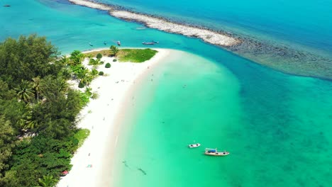 paradise beach of tropical island with white sand washed by crystal emerald water of turquoise lagoon with boats floating, thailand