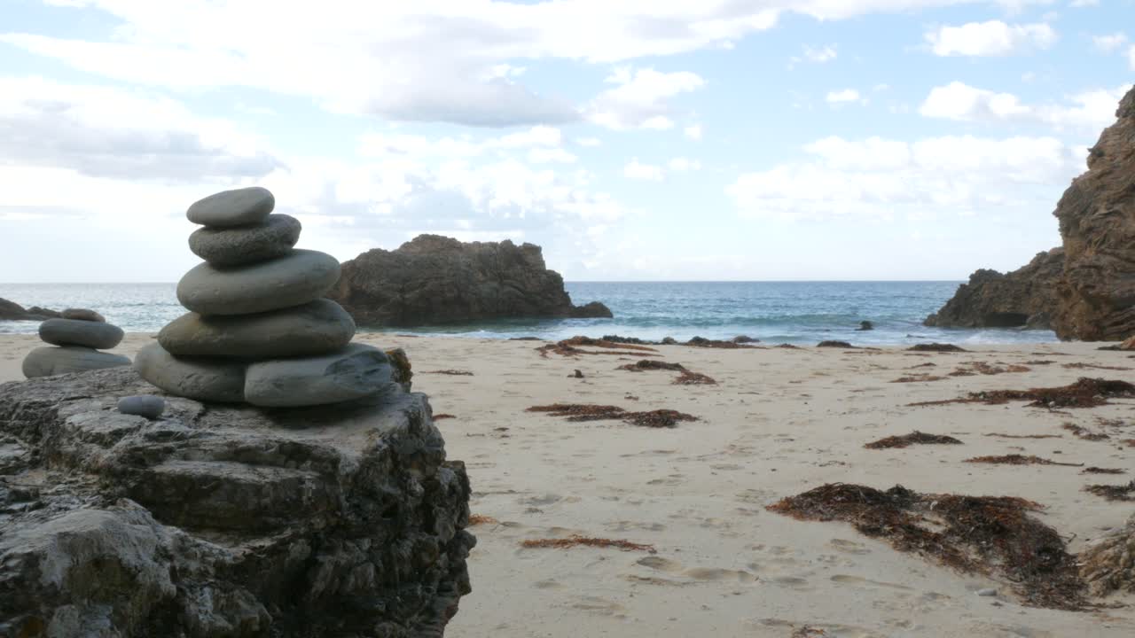 배경 에 바다 와 파도 가 있는 명상적 인 바위 어리 의 손잡이