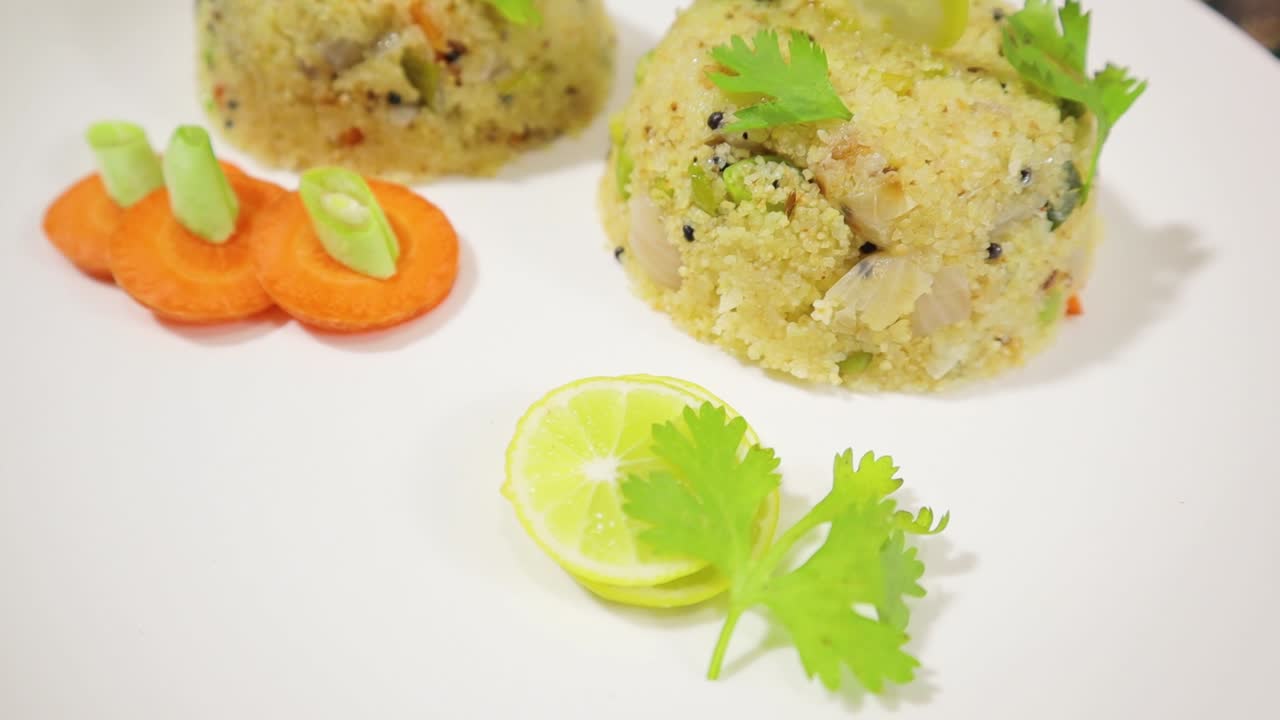 cierre giratorio del desayuno matutino del sur de la india upma o uppittu en un plato
