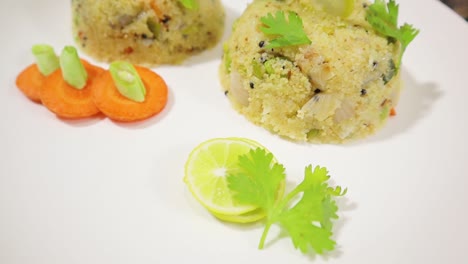 rotating close up of south indian morning breakfast upma or uppittu on plate