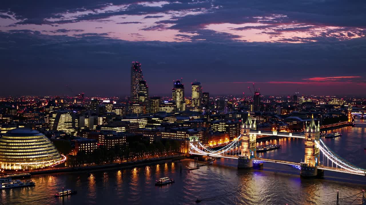 Aerial video captures London's skyline at dusk, highlighting the illuminated Tower Bridge