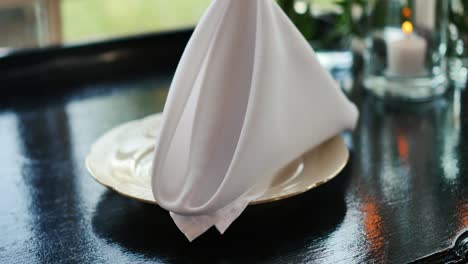 folded white napkin on plate on wedding table