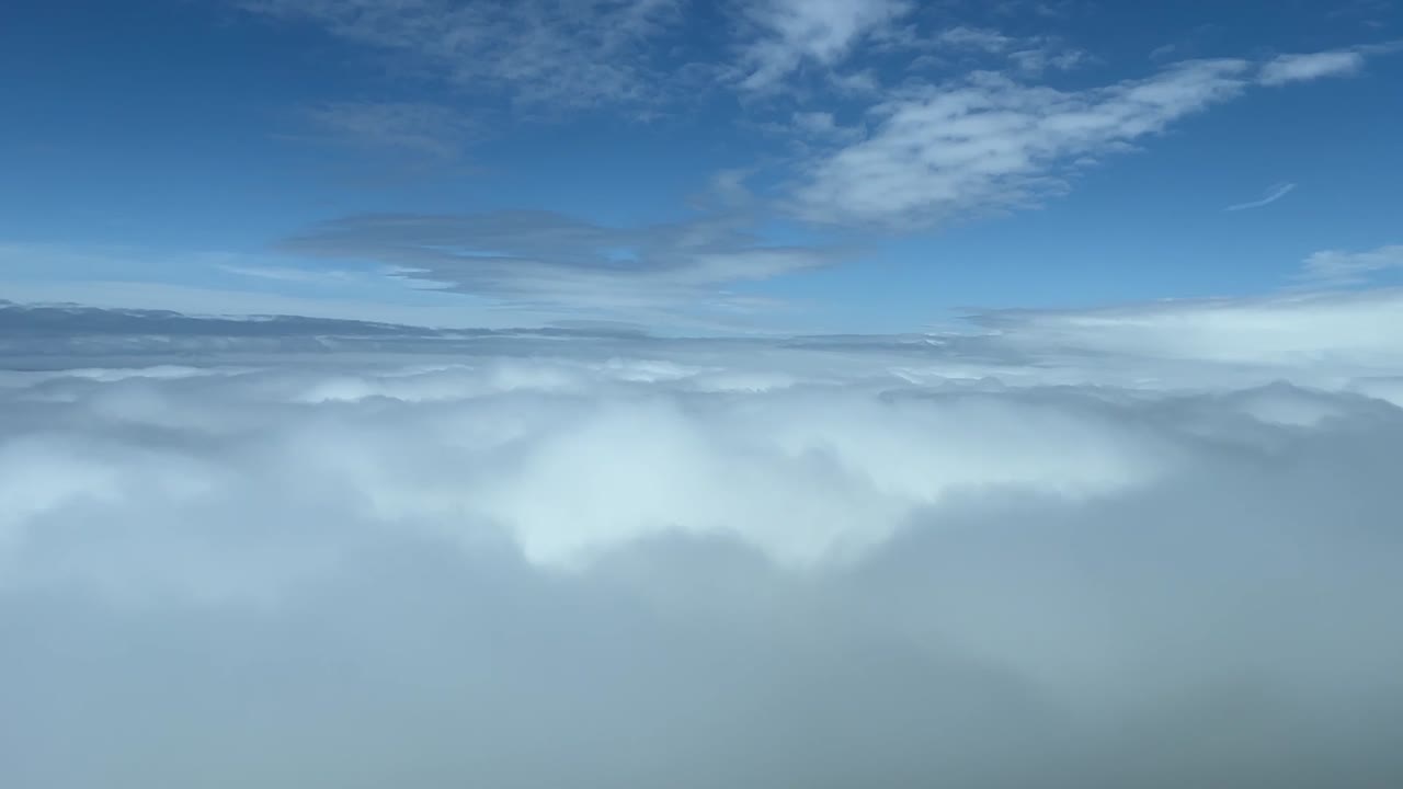 Cockpit view overflying a sea of clouds daylight
