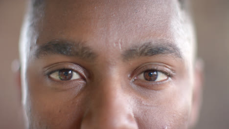 portrait of happy african american casual businessman opening eyes in office in slow motion