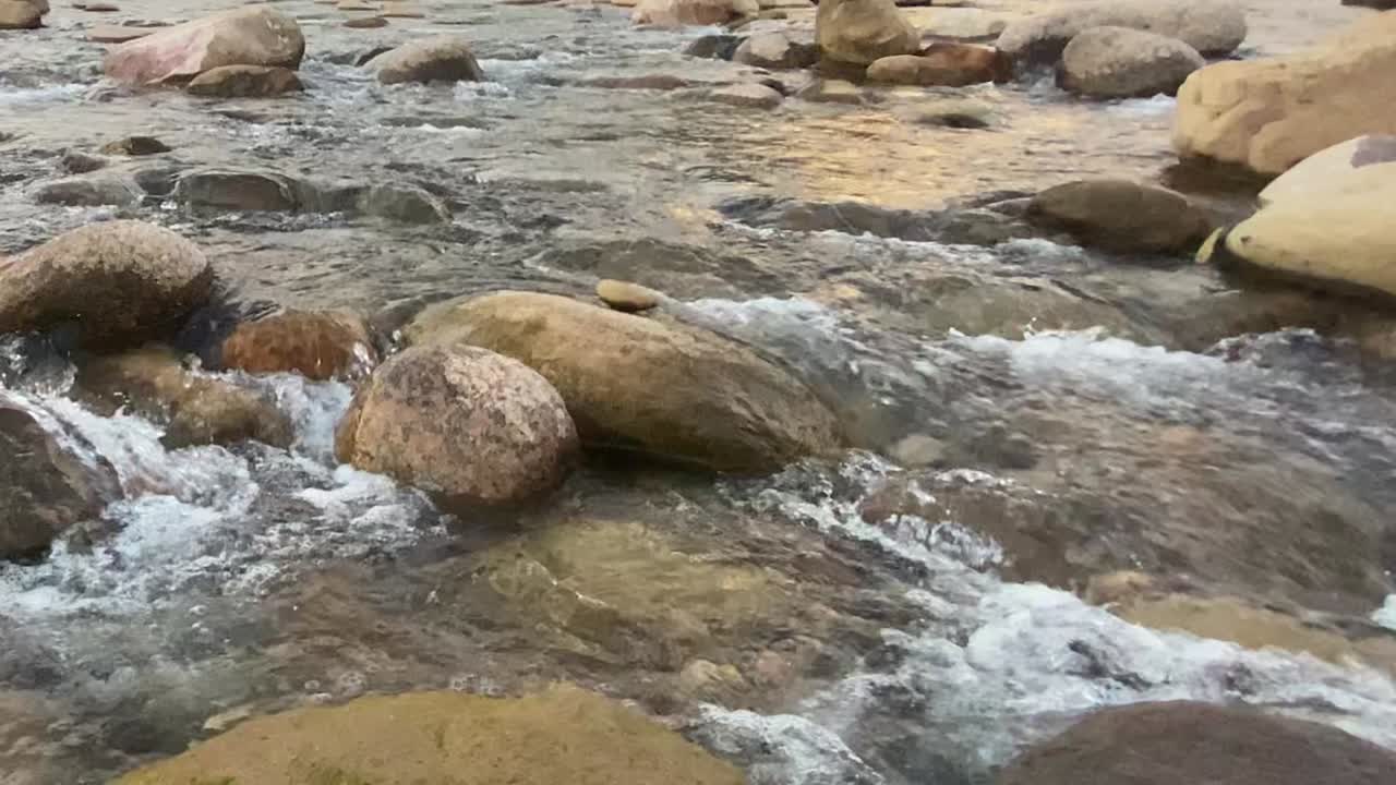 Acqua cristallina che scorre tra le rocce lungo una valle montana a Sylhet, Bangladesh.