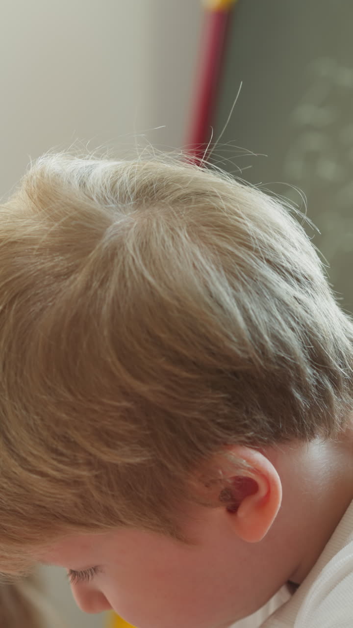 маленький брат думает, что трогает губу, в то время как сестра страдает от скуки в домашнем классе вблизи. девочка ждет мечты малыша, решающего задачи в детской комнате