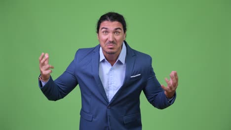 angry businessman gesturing and talking to camera