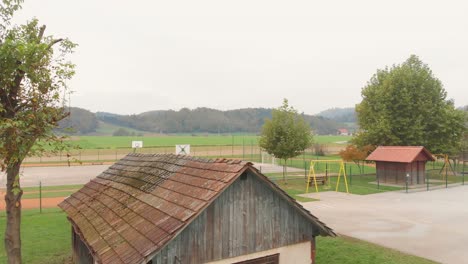 una vista de drones sobre una vieja cabaña con la cancha de baloncesto en un pueblo en un valle hermoso y fascinante