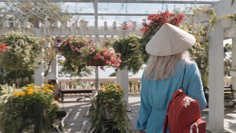 A-girl-walks-with-a-Vietnamese-hat-in-the-park-of-Ba-Na-Hills,-Vietnam