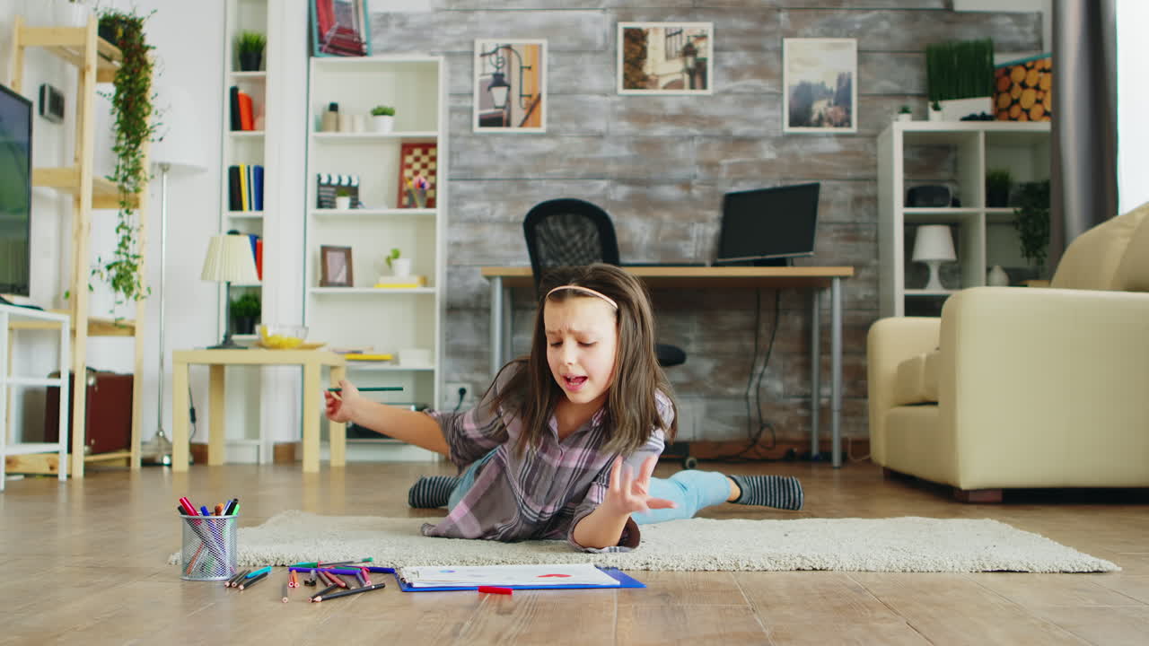 Happy little girl lying on the floor in living room