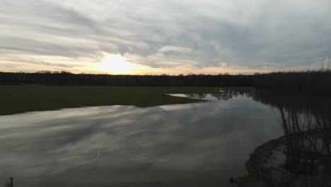 Blick-Auf-Den-Sonnenuntergang-über-Dem-Loosahatchie-River-Mit-Einer-Kleinen-Hütte,-Tennessee,-USA,-Ruhige-Landschaft,-Luftaufnahme