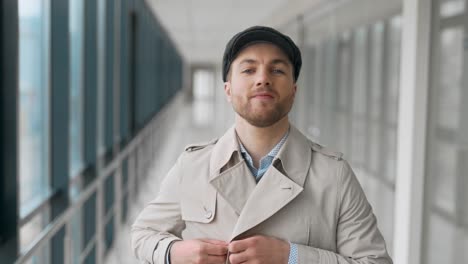 handsome adult man with a beard in a coat posing in front of the camera