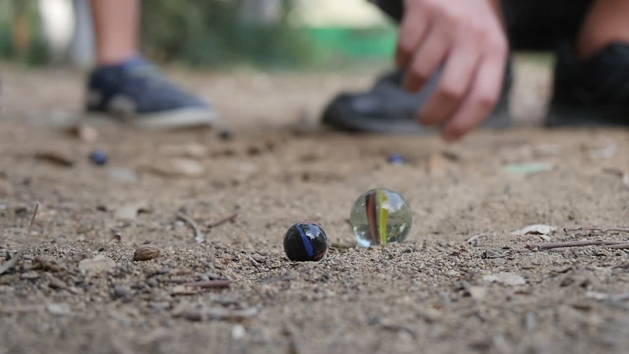 Primo piano di bambini che giocano a biglie nella sabbia