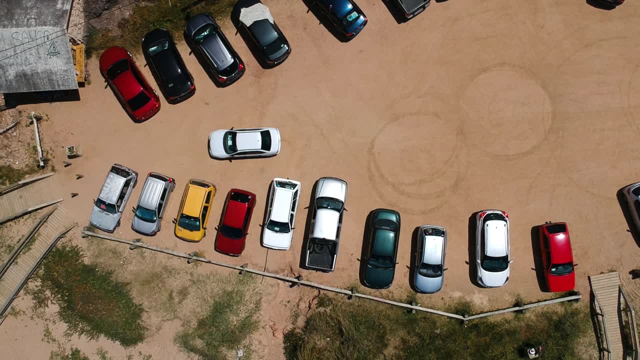 toma aérea de un camión que sale de un estacionamiento de tierra