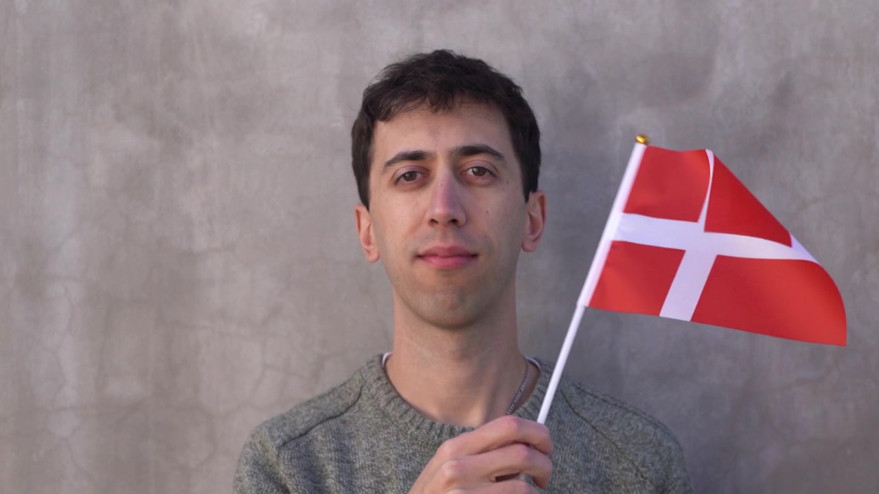 Mężczyzna machający duńską flagą. Zbliżenie w zwolnionym tempie.