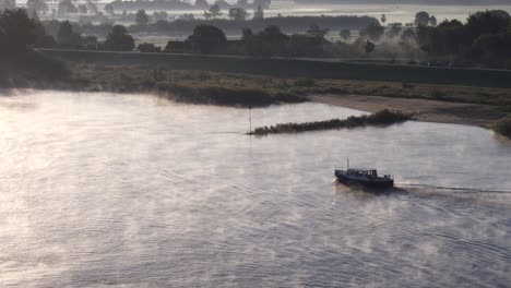 misty river sunrise with boat