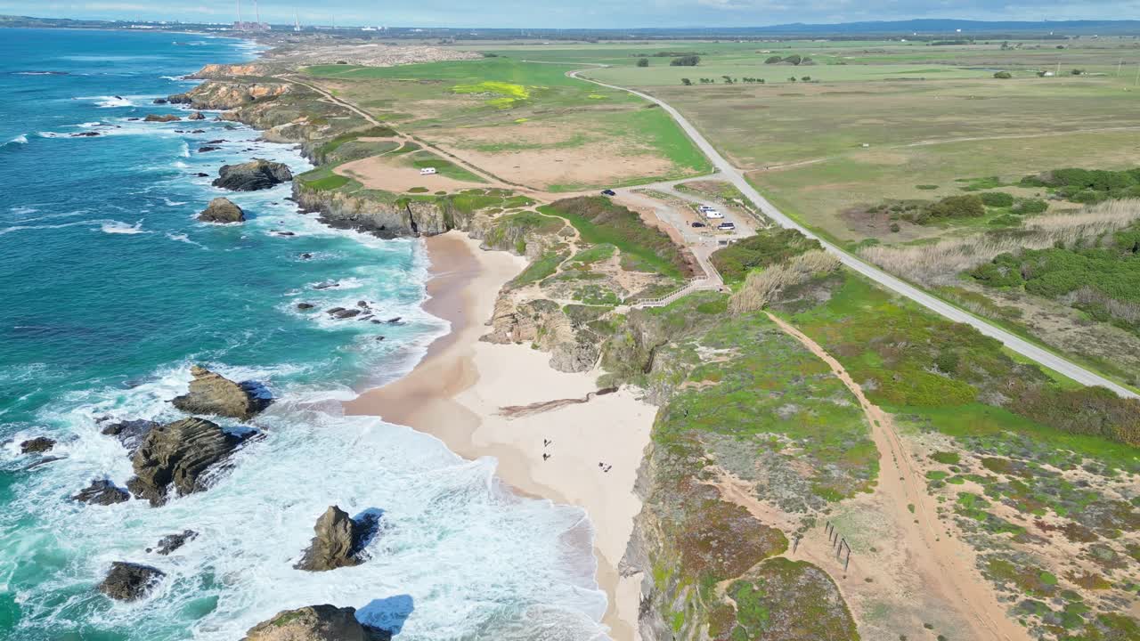 Cliffside beach with turquoise waves in Alentejo, Portugal, aerial summer view