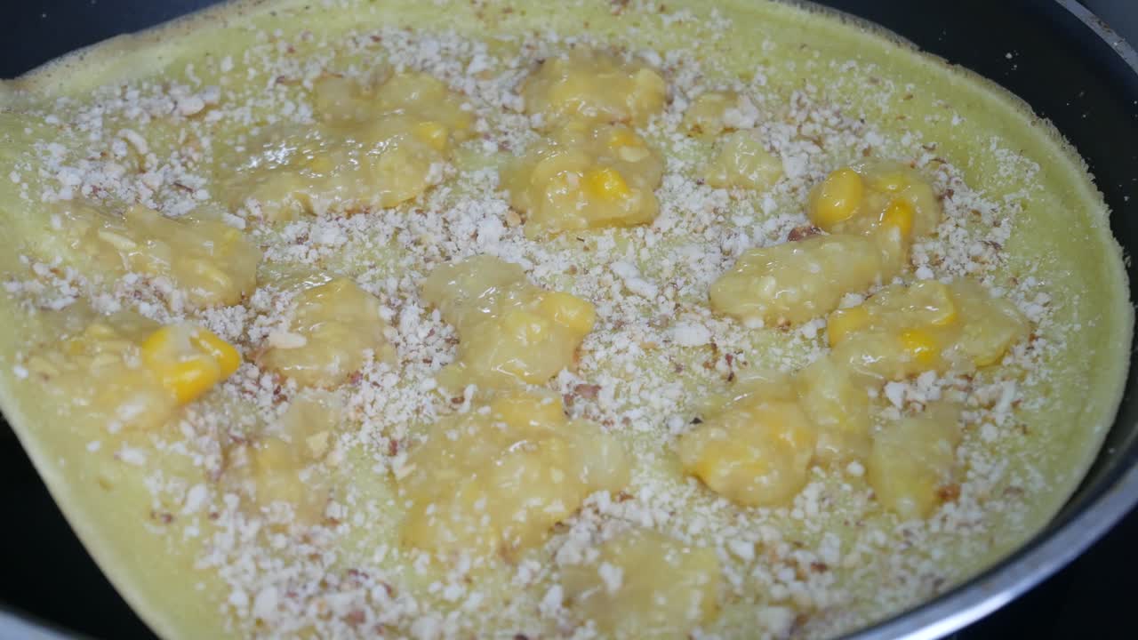 Apam balik or Malaysian Peanut Pancake turnover.  Flour pancake stuffed with sugar and corn topping. Cooked using the hot pan. Famous street food in Malaysia