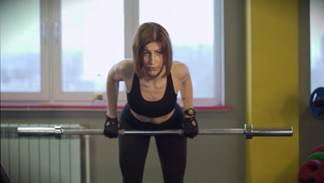 mujer levantando pesas en un gimnasio