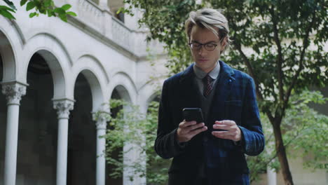 Student-browsing-internet-on-phone-at-college