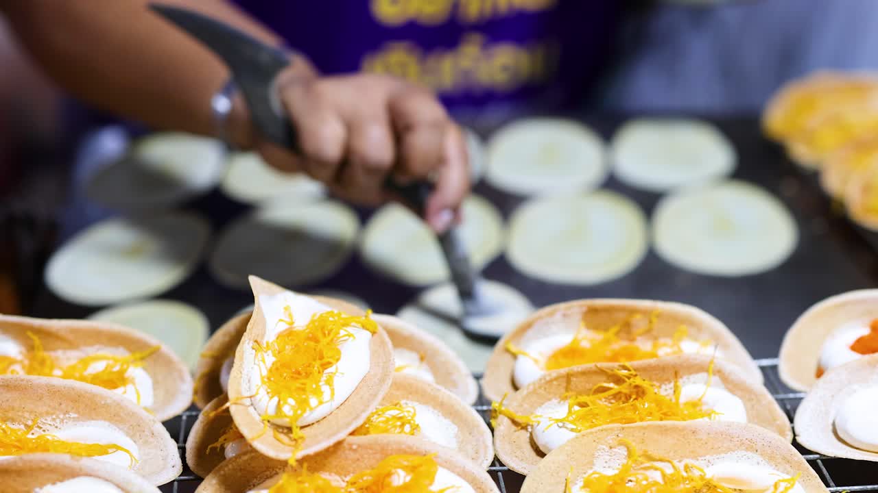 el vendedor prepara panqueques tradicionales tailandeses crujientes