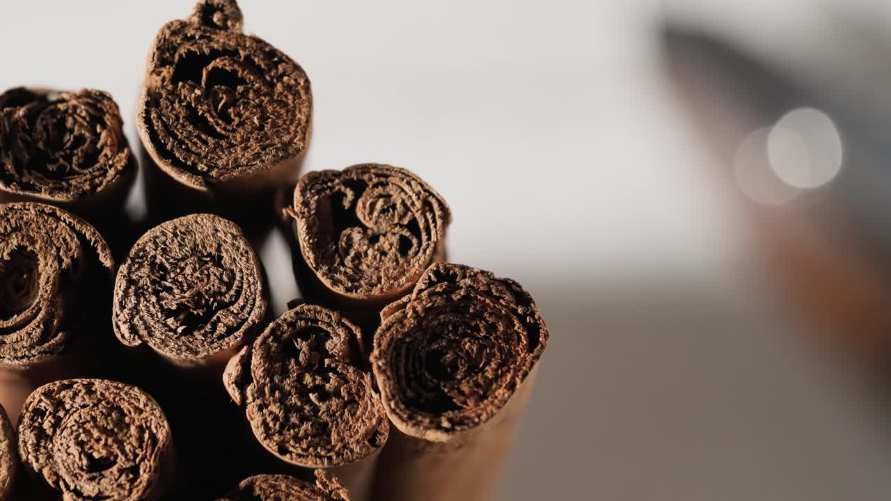 la luz se enciende lentamente revelando un montón de palitos de canela, un primer plano extremo