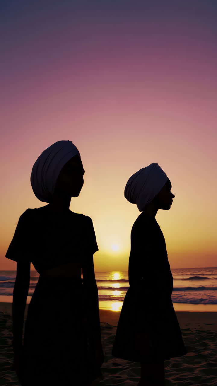 Silhouettes of people on a vibrant beach at sunset