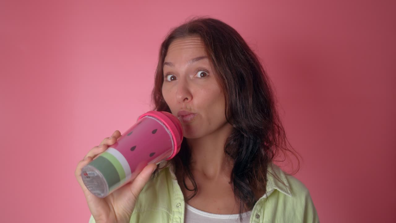 Woman drinking from a watermelon-themed tumbler