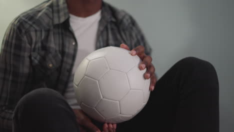 African-American-man-plays-with-ball-siting-on-bean-chair