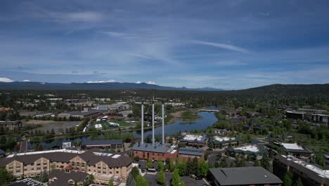 The-Old-Mill-in-Bend,-Oregon-with-Deschutes-River-and-Cascade-Mountains-in-the-distance