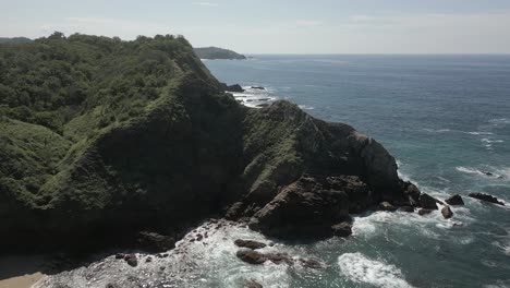 low flyover: bright sparkly ocean water meets jagged rocky sea coast