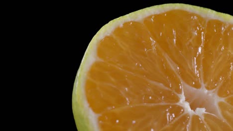 footage of sliced rotating tangerine on black background