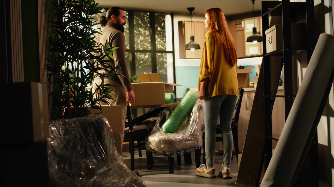 Couple Moving Into New Home and Unpacking Cardboard Boxes