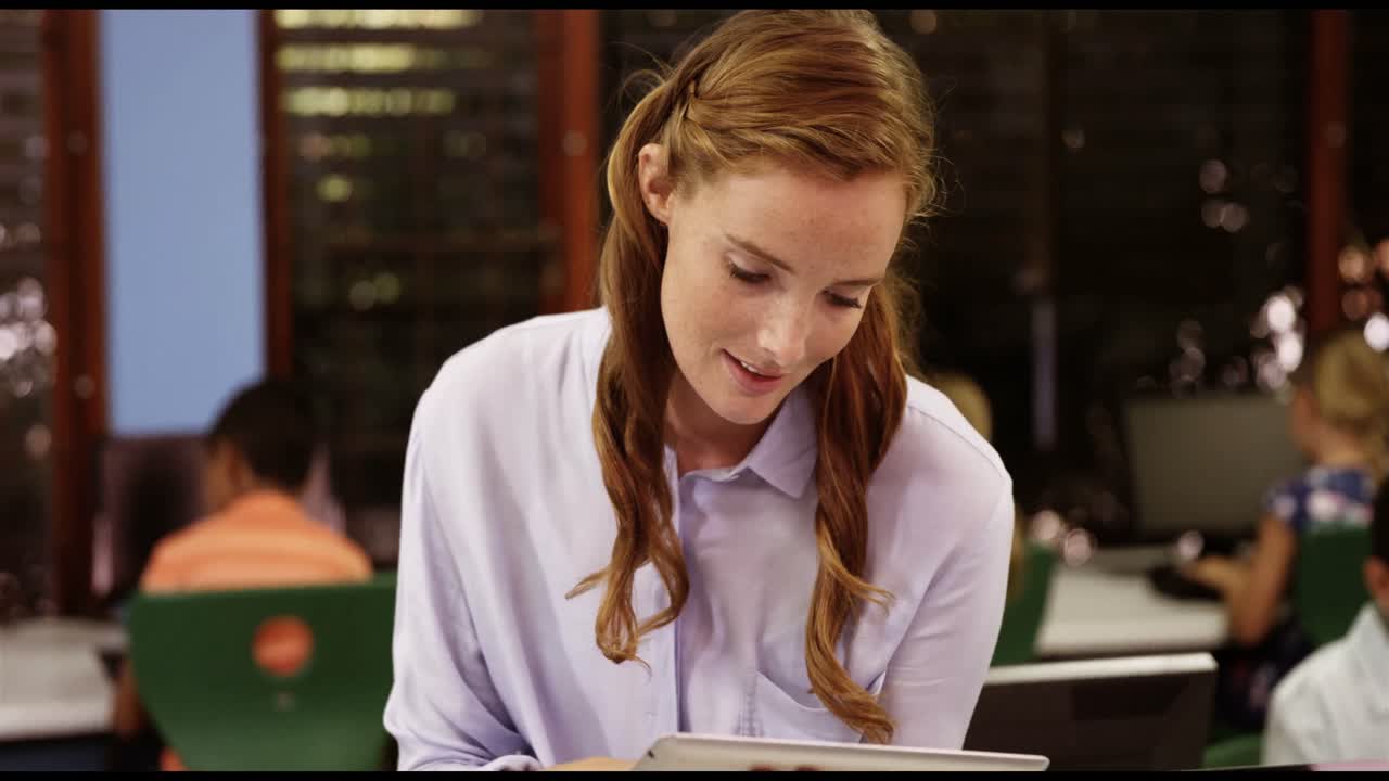 Teacher using digital tablet in classroom