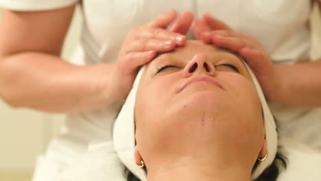 woman relaxing during facial therapy at beauty spa