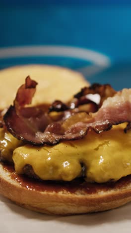 chef adding onion rings to complete the gourmet burger