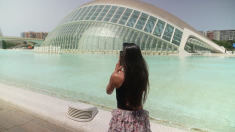 mujer tomando una foto de la arquitectura moderna en la ciudad