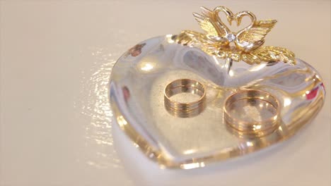 anillos de bodas en un plato en forma de corazón