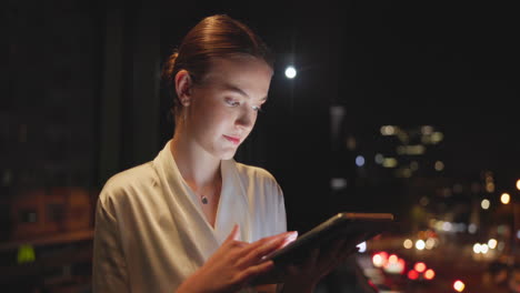 woman using a tablet at night