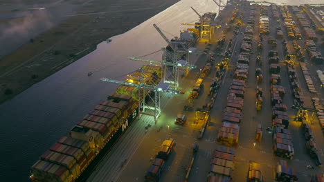 The-Port-of-Oakland-at-night-with-containers-being-loaded-on-shipping-vessels---aerial-orbiting-view