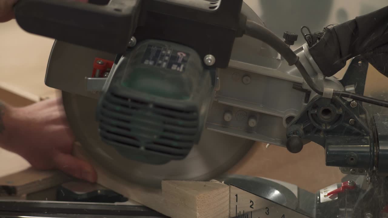 A side view of a miter saw cutting a work piece at a selected angle