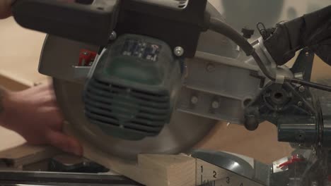 a side view of a miter saw cutting a work piece at a selected angle