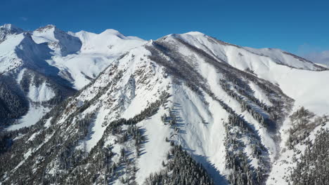 air flight through mountain clouds over beautiful snow-capped peaks of mountains and glaciers.