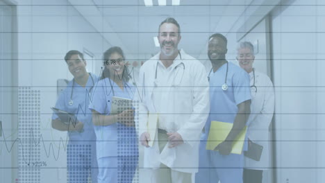 medical team holding digital tablet, standing in corridor displaying animated financial line charts